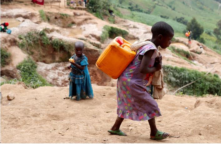 دختری ظرف آب را در معدن کولتان در کاماتاره، قلمرو ماسیسی، استان کیوو شمالی جمهوری دموکراتیک کنگو حمل می کند.
